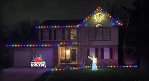 brick house with angel and colorful Christmas lights and pressure doctor logo