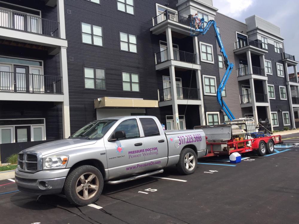 pressure doctor cleaning black apartment building in gray pressure doctor work truck