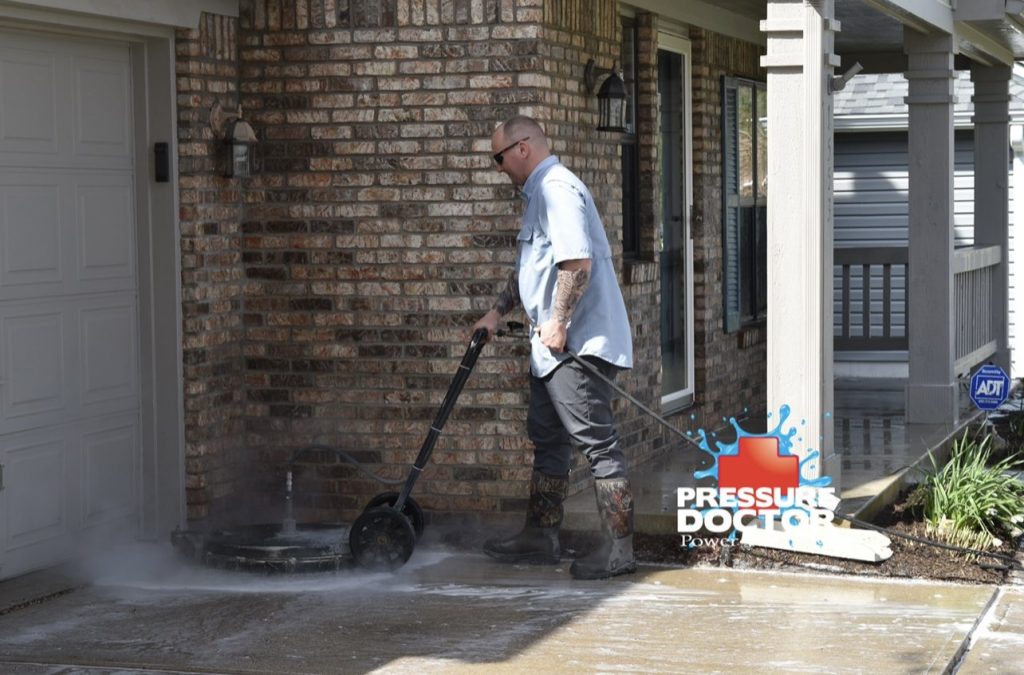pressure doctor professional pressure washing concrete in front of brick home